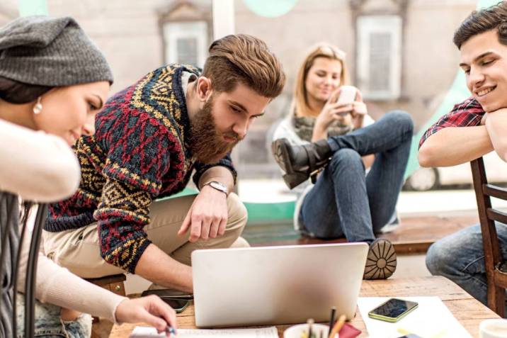 Group of young people using laptop.