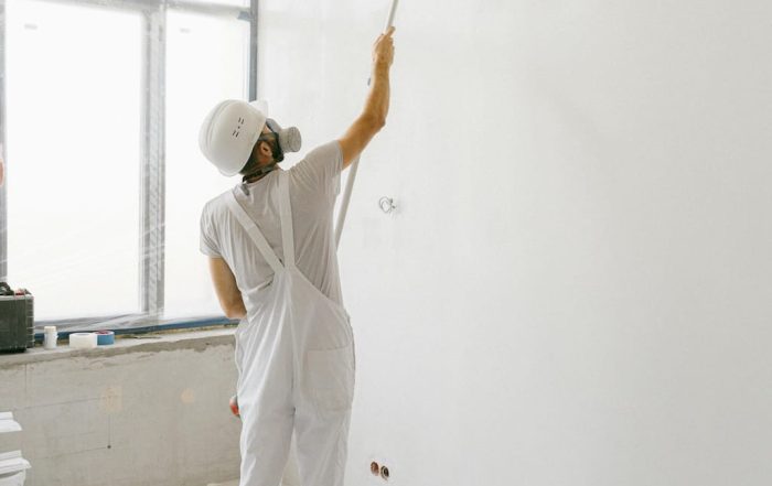 Personas pintando una habitación con pintura de calidad