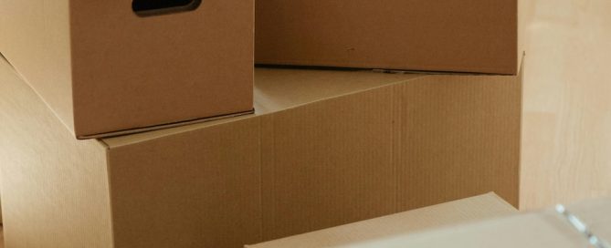Persona organizando cajas y embalando objetos durante una mudanza sin estrés