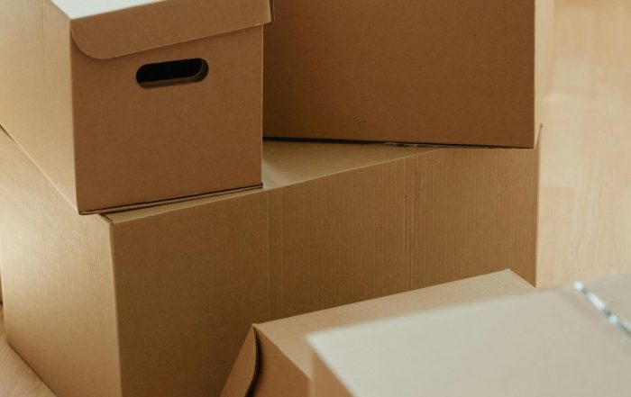 Persona organizando cajas y embalando objetos durante una mudanza sin estrés
