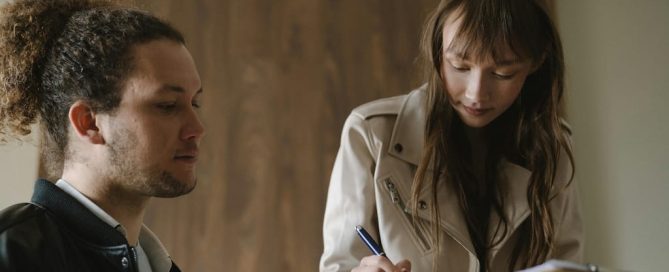 Joven firmando contrato de alquiler por primera vez en una oficina inmobiliaria