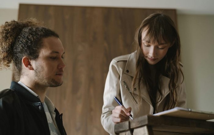 Joven firmando contrato de alquiler por primera vez en una oficina inmobiliaria